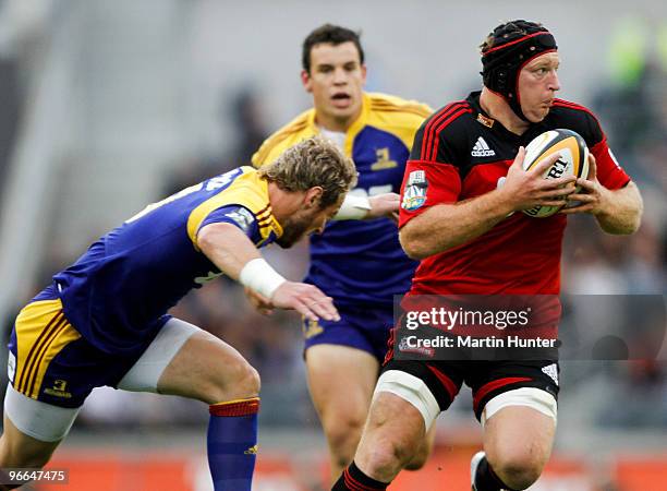 Thomas Waldrom of the Crusaders looks to offload as he is tackled by Jimmy Cowan of the Higlanders during the round one Super 14 match between the...