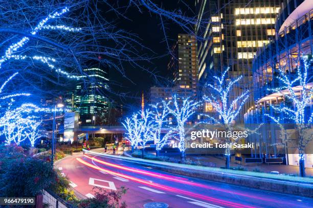 cars go through among the illuminated trees line street along high-rise buildings at tokyo midtown roppongi tokyo japan on december 21 2017. over 500,000 led lights illuminate the street and surround the area for christmas illumination event. - car blinker stock pictures, royalty-free photos & images