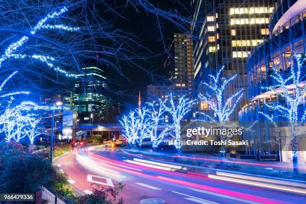cars go through among the illuminated trees line street along high-rise buildings at tokyo midtown roppongi tokyo japan on december 21 2017. over 500,000 led lights illuminate the street and surround the area for christmas illumination event. - car blinker stock pictures, royalty-free photos & images