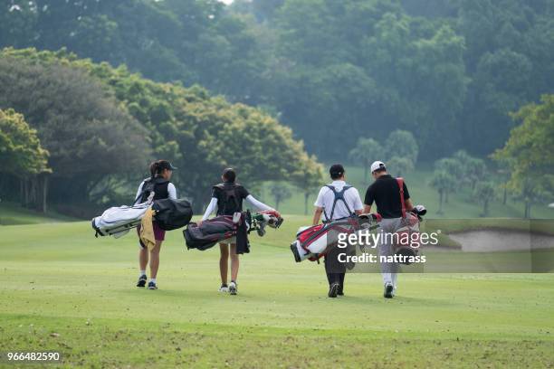 friends walk together down the fairway - golfer stock pictures, royalty-free photos & images