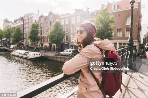 woman walking near canal in amsterdam at sunset - amsterdam spring stock pictures, royalty-free photos & images