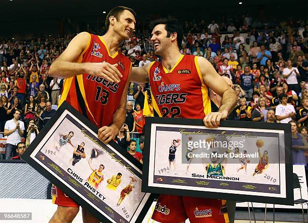 Retiring Tigers greats Chris Anstey and Sam MacKinnon congratulate each other after being presented with framed mementos during the round 20 NBL...