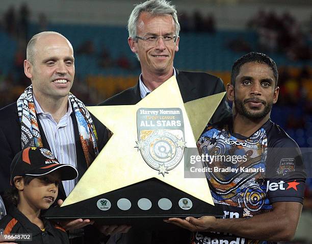 Preston Campbell of the Indigenous All Stars team is presented with the wnning trophy after the Indigenous All Stars and the NRL All Stars match at...