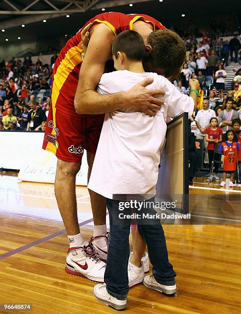 Chris Anstey of the Tigers hugs his children after finishing playing his last game in the round 20 NBL match between the Melbourne Tigers and the...