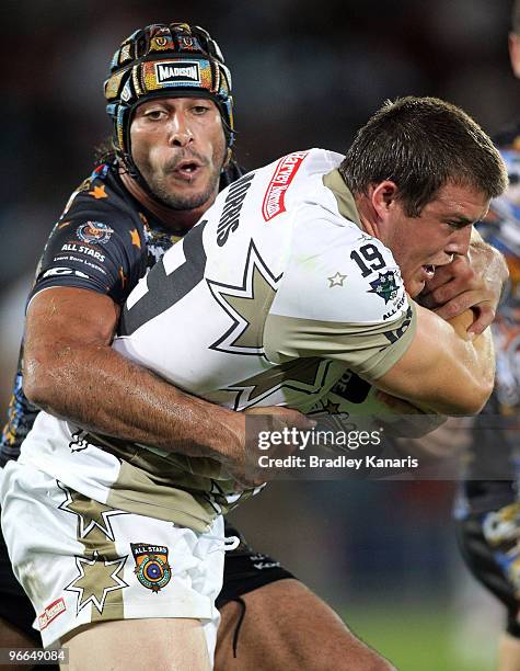 Josh Morris of the NRL All Stars team is tackled by Johnathan Thurston of the Indigenous All Stars team during the Indigenous All Stars and the NRL...