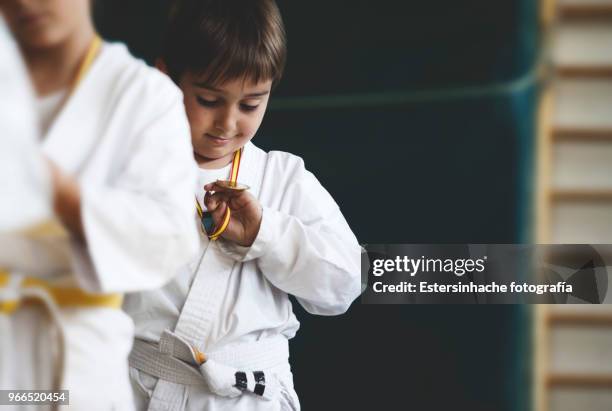 photograph of a little boy looking happy at a medal won practicing karate - pride of sport awards stock pictures, royalty-free photos & images