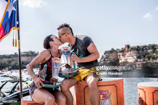 In this handout image provided by Red Bull, Third placed woman Anna Bader of Germany and men`s winner Kris Kolanus of Poland celebrate on the podium...