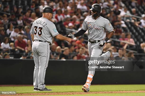 Lewis Brinson of the Miami Marlins is congratulated by third base coach Fredi Gonzalez after hitting a solo home run in the ninth inning of the MLB...