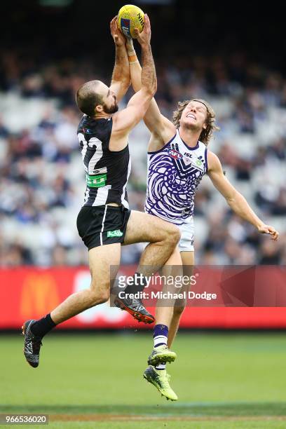 Steele Sidebottom of the Magpies marks the ball against Ed Langdon of the Dockers during the round 11 AFL match between the Collingwood Magpies and...