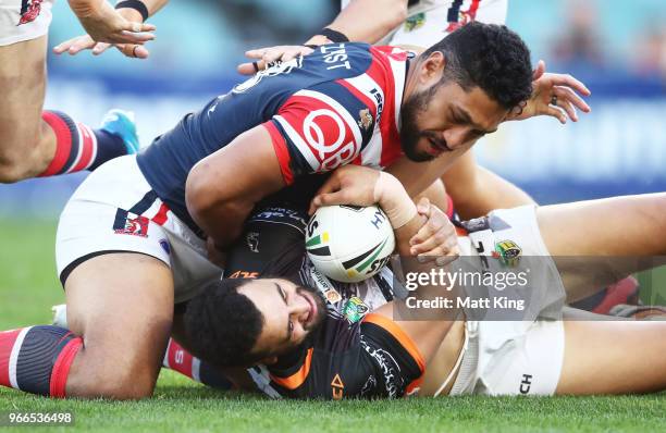 Ben Matulino of the Tigers is tackled by Isaac Liu of the Roosters during the round 13 NRL match between the Sydney Roosters and the Wests Tigers at...