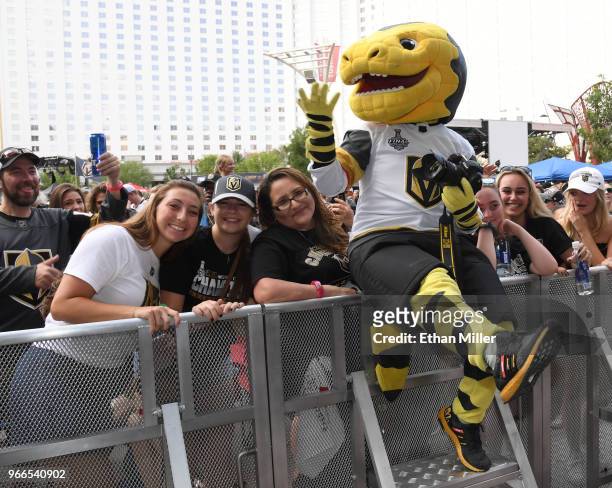The Vegas Golden Knights mascot Chance the Golden Gila Monster jokes around with fans at a Golden Knights road game watch party for Game Three of the...