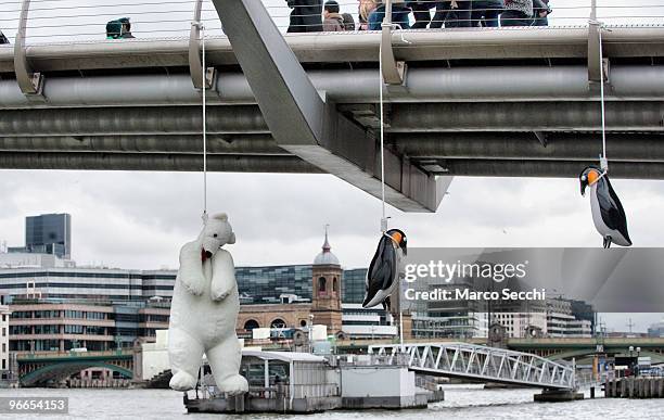 Suicide Penguins" by Taiwanese artist Vincent Huang hangs from the Millennium Bridge on February 13, 2010 in London, England. The installation is...