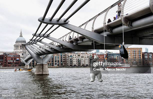 Suicide Penguins" by Taiwanese artist Vincent Huang hangs from the Millennium Bridge on February 13, 2010 in London, England. The installation is...