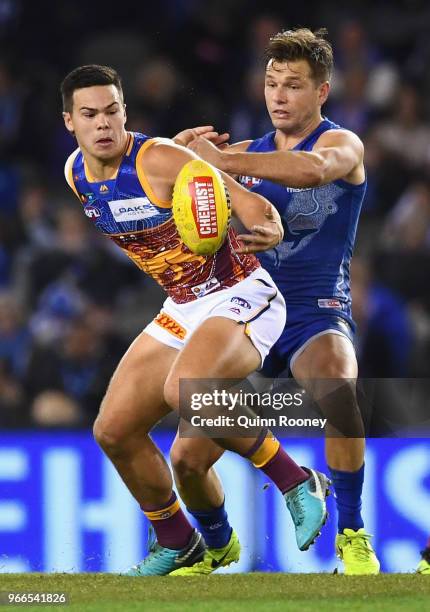 Cameron Rayner of the Lions and Shaun Higgins of the Kangaroos compete for the ball during the round 11 AFL match between the North Melbourne...