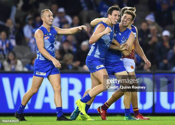 Sam Wright of the Kangaroos is congratulated by team mates after kicking a goal during the round 11 AFL match between the North Melbourne Kangaroos...
