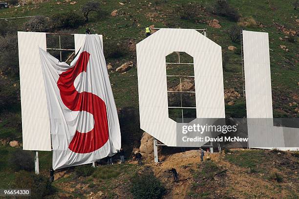 Activists begin covering up the iconic 450-foot-long Hollywood sign during an effort to prevent the building of houses there on February 11, 2010 in...