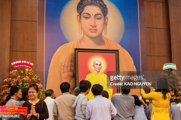 Buddhists take pictures of a portrait of monk Thich Quang Duc, who set himself on fire on a busy Saigon street corner in 1963, at the at Vietnam Quoc...