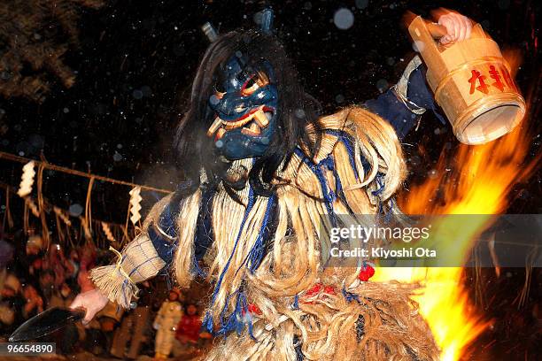 Man dressed in straw clothes and an orge mask as Namahage, or a mountain demon, performs dances during the Namahage Sedo Festival at Shinzan Shrine...