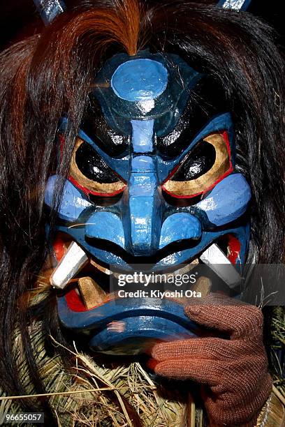 Man dressed in straw clothes and an orge mask as Namahage, or a mountain demon, marches through the grounds of the shrine during the Namahage Sedo...