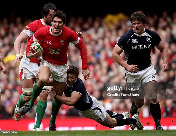 James Hook of Wales is tackled by Chris Cusiter of Scotland during the RBS 6 Nations match between Wales and Scotland at the Millennium Stadium on...