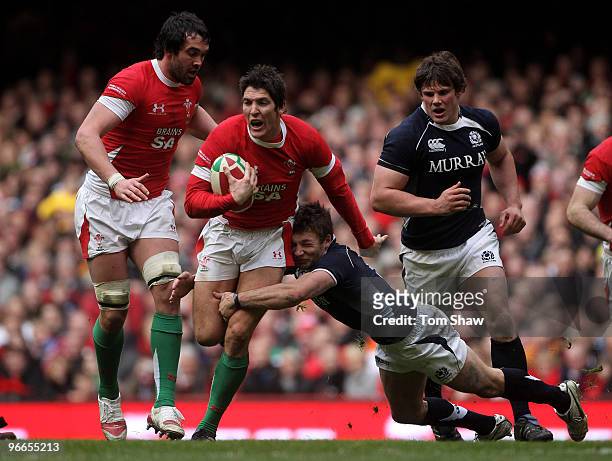 James Hook of Wales is tackled by Chris Cusiter of Scotland during the RBS 6 Nations match between Wales and Scotland at the Millennium Stadium on...
