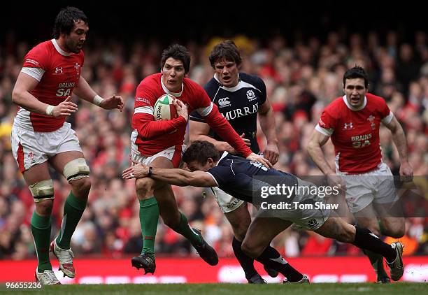 James Hook of Wales is tackled by Chris Cusiter of Scotland during the RBS 6 Nations match between Wales and Scotland at the Millennium Stadium on...