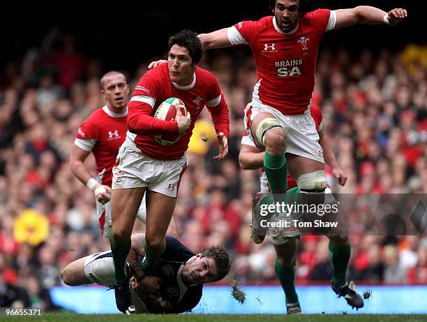 James Hook of Wales is tackled by Chris Cusiter of Scotland during the RBS 6 Nations match between Wales and Scotland at the Millennium Stadium on...