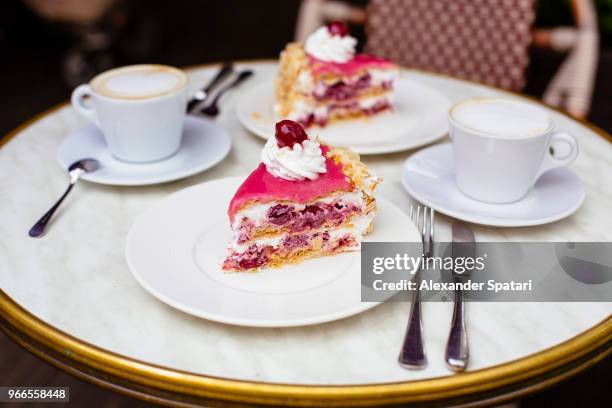 cherry cake and cappuccino on the table in a cafe - cafe culture uk stock pictures, royalty-free photos & images