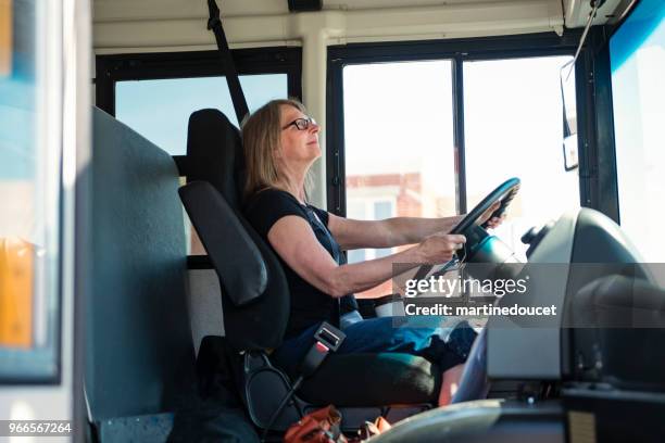 retrato de mujer madura conduciendo un autobús escolar. - mujer conduciendo fotografías e imágenes de stock