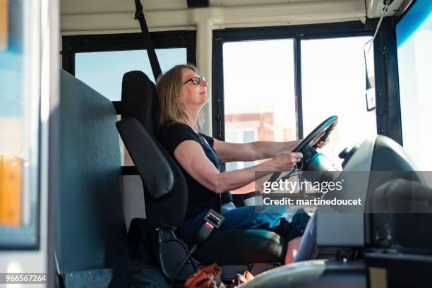 学校のバスを運転する成熟した女性の肖像画。 - バス運転手 ストックフォトと画像