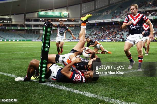 Corey Thompson of the Tigers is tackled over the line in the corner by Daniel Tupou of the Roosters in the final minutes during the round 13 NRL...