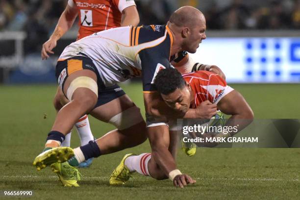 Sunwolves' Sione Teaupa is tackled by Brumbies' Lach McCaffrey during the Super Rugby match between the ACT Brumbies and Japan's Sunwolves in...