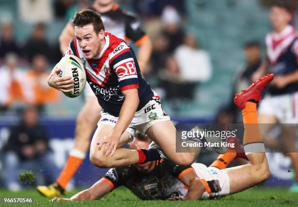 Luke Keary of the Roosters is ankle tapped by Josh Reynolds of the Tigers during the round 13 NRL match between the Sydney Roosters and the Wests...