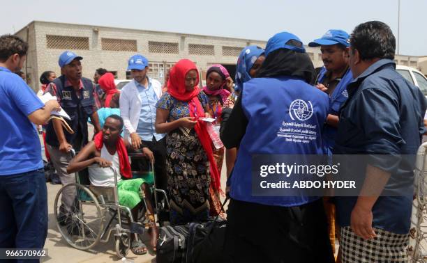 Employees of the International Organisation for Migration assist Ethiopian migrants to board a ship repatriating them home via Djibouti, in Yemen's...