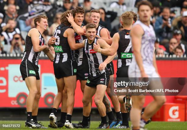Brody Mihocek of the Magpies is congratulated by Will Hoskin-Elliott and his teammates after kicking his first goal during the round 11 AFL match...