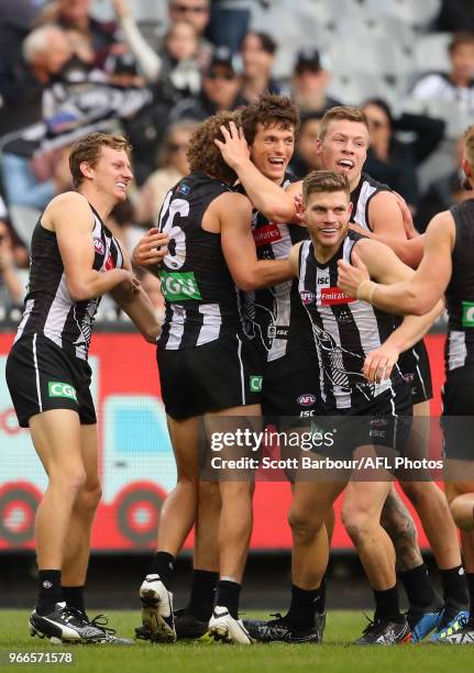 Brody Mihocek of the Magpies is congratulated by Will Hoskin-Elliott and his teammates after kicking his first goal during the round 11 AFL match...