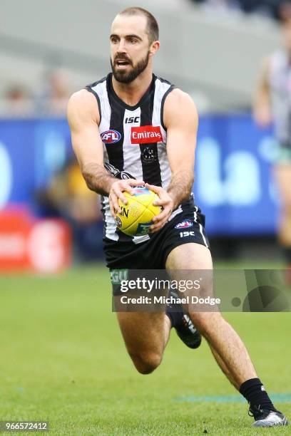 Steele Sidebottom of the Magpies runs with the ball during the round 11 AFL match between the Collingwood Magpies and the Fremantle Dockers at...