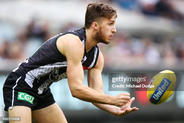 Tom Phillips of the Magpies handballs during the round 11 AFL match between the Collingwood Magpies and the Fremantle Dockers at Melbourne Cricket...