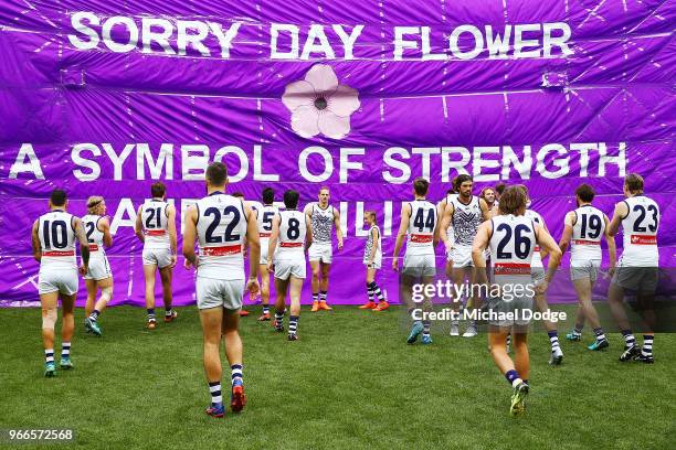 Dockers players break through their banner during the round 11 AFL match between the Collingwood Magpies and the Fremantle Dockers at Melbourne...