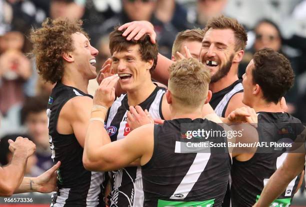 Brody Mihocek of the Magpies is congratulated by his teammates after kicking his first goal during the round 11 AFL match between the Collingwood...