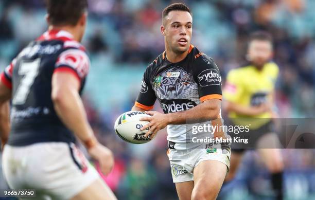 Luke Brooks of the Tigers runs with the ball during the round 13 NRL match between the Sydney Roosters and the Wests Tigers at Allianz Stadium on...