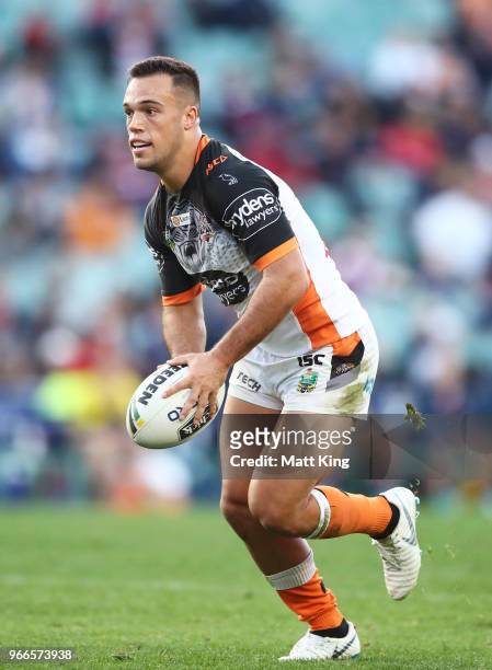 Luke Brooks of the Tigers runs with the ball during the round 13 NRL match between the Sydney Roosters and the Wests Tigers at Allianz Stadium on...