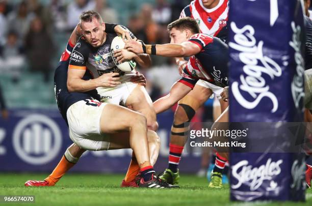 Josh Reynolds of the Tigers is tackled during the round 13 NRL match between the Sydney Roosters and the Wests Tigers at Allianz Stadium on June 3,...