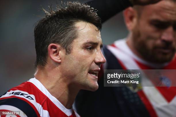 Cooper Cronk of the Roosters talks to team mates during the round 13 NRL match between the Sydney Roosters and the Wests Tigers at Allianz Stadium on...