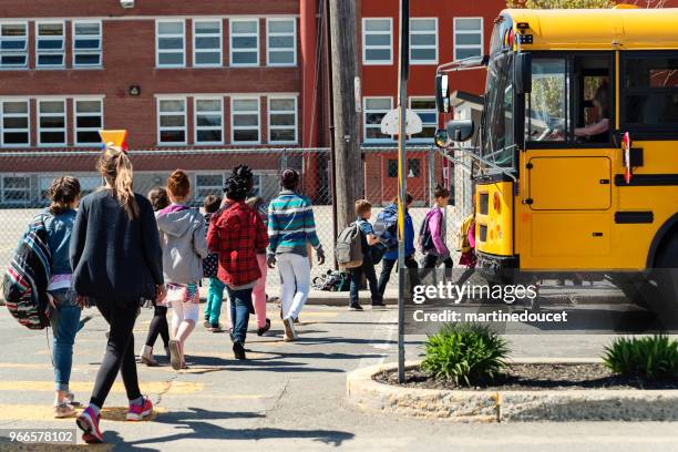 kids in line crossing street to get on school bus. - leaving school imagens e fotografias de stock