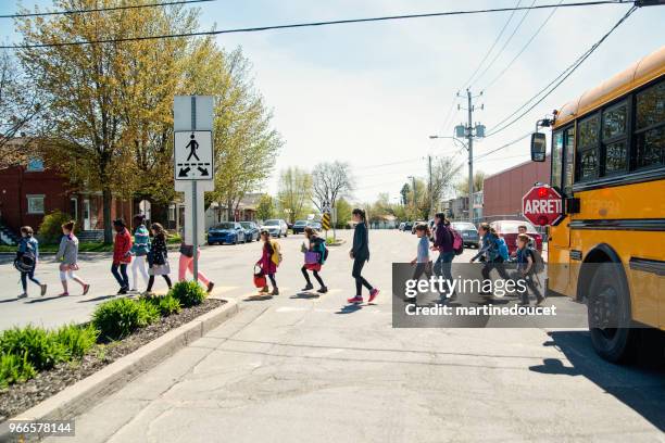 kids in line crossing street getting out of school bus. - quebec road stock pictures, royalty-free photos & images