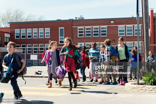 group of multi-ethnic kids crossing street getting out school. - leaving school imagens e fotografias de stock