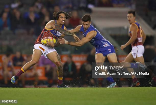 Allen Christensen of the Lions is tackled by Jy Simpkin of the Kangaroos during the 2018 AFL round 11 match between the North Melbourne Kangaroos and...