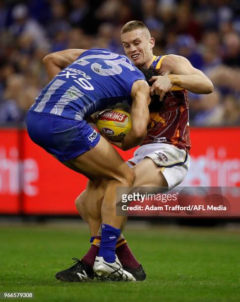 Robbie Tarrant of the Kangaroos is tackled by Dayne Beams of the Lions during the 2018 AFL round 11 match between the North Melbourne Kangaroos and...