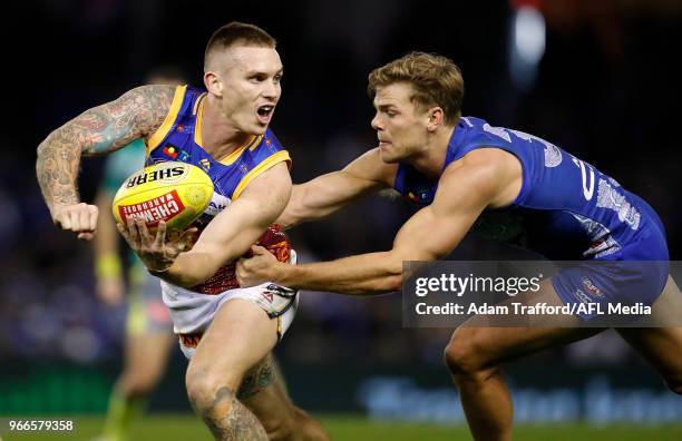 Dayne Beams of the Lions is tackled by Mason Wood of the Kangaroos during the 2018 AFL round 11 match between the North Melbourne Kangaroos and the...